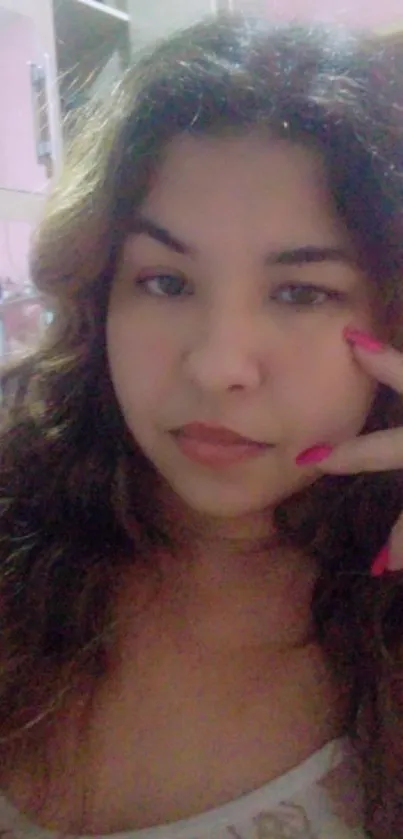 A woman's portrait with pink nails and soft lighting.