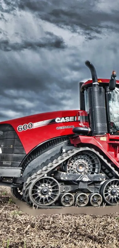 Vivid red tractor in a field under a stormy sky.