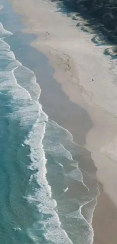 Aerial view of a pristine beach with waves gently lapping the shore.