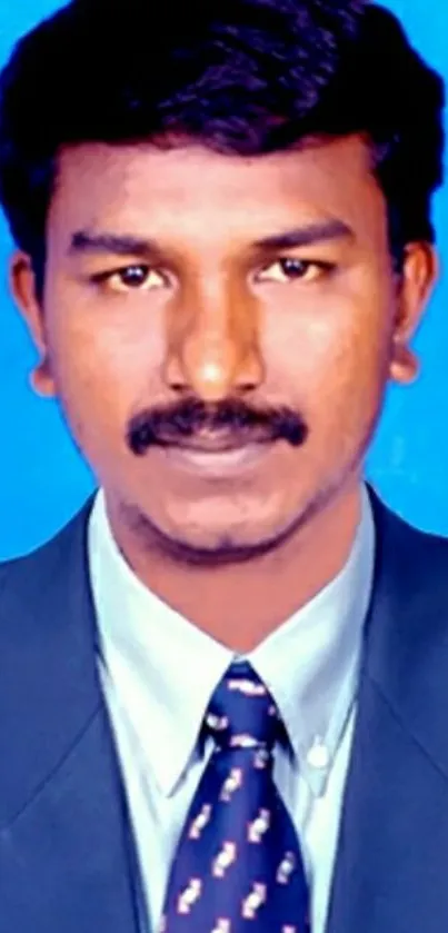 Professional portrait with blue background in formal attire.