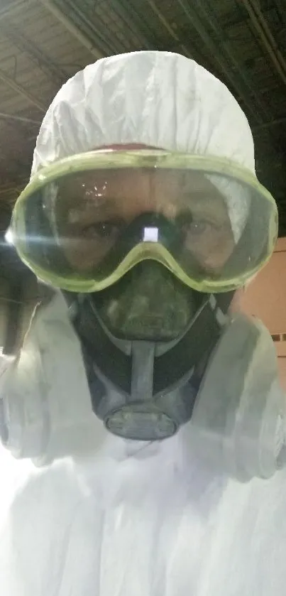 Person wearing full protective gear with mask and goggles in industrial setting.