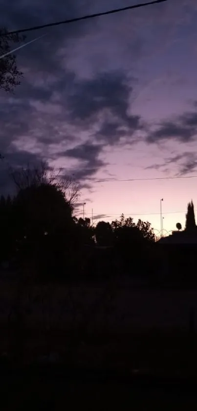 Dark silhouette against purple evening sky with clouds