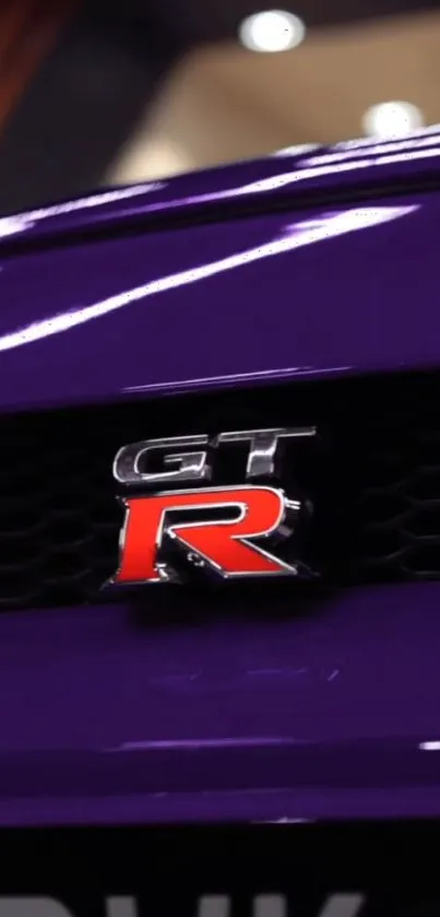 Close-up of a purple GT car emblem on a sports vehicle.