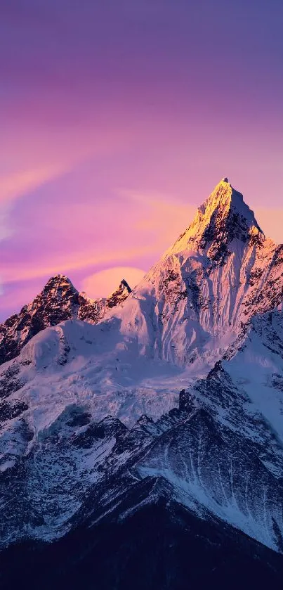 Snow-capped mountain under a glowing purple sky during evening.