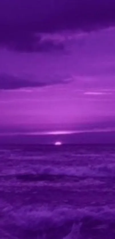 Purple sunset over ocean with calm waves.