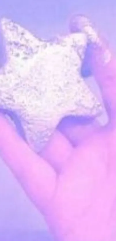 Hand holding a shimmering silver star with a purple background.