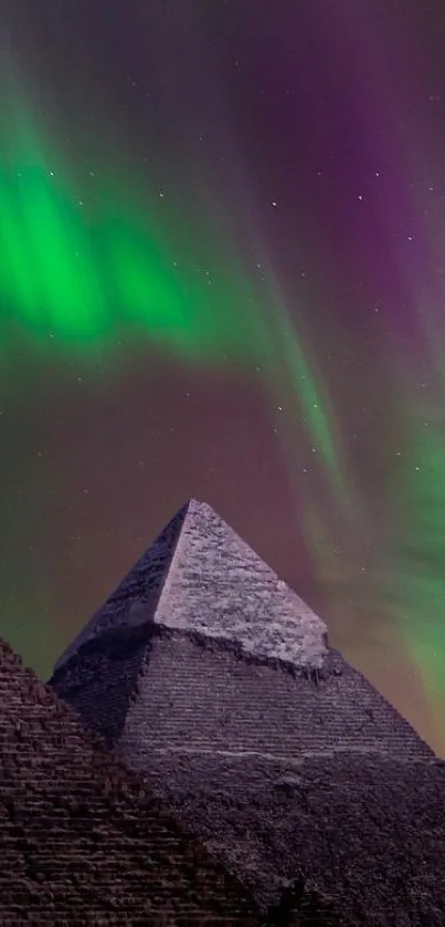 Pyramids illuminated by vibrant aurora lights against a purple night sky.