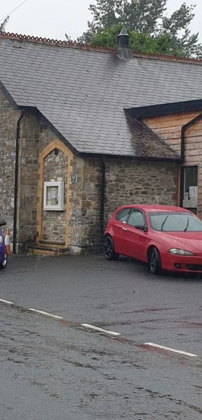 Stone building with cars on wet road, creating a calming street view.