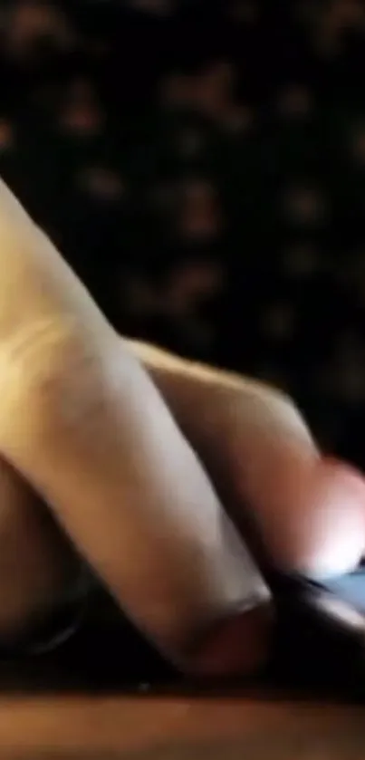 Close-up of a hand touching a phone screen with a dark background.