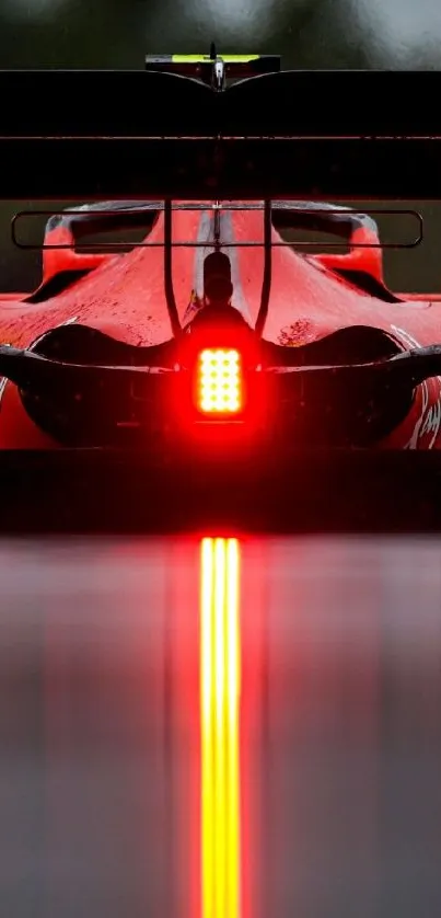 Rear view of a racing car with glowing red lights on a wet track.