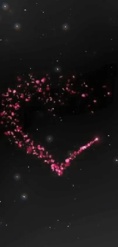 Pink heart shape made with glowing particles on a black background.