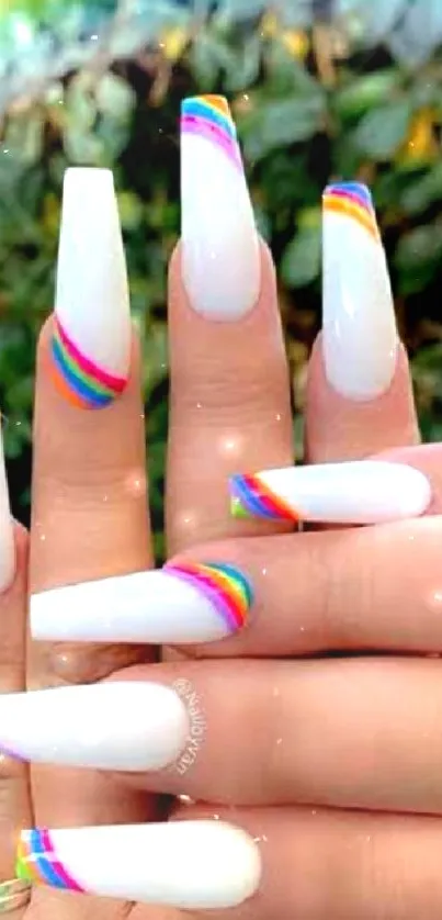 Close-up of hands with elegant rainbow nail art.