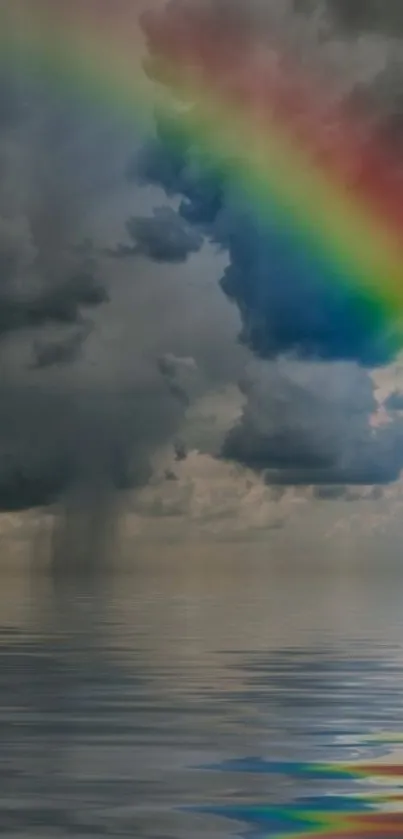 Cloudy sky with a vibrant rainbow over calm water.