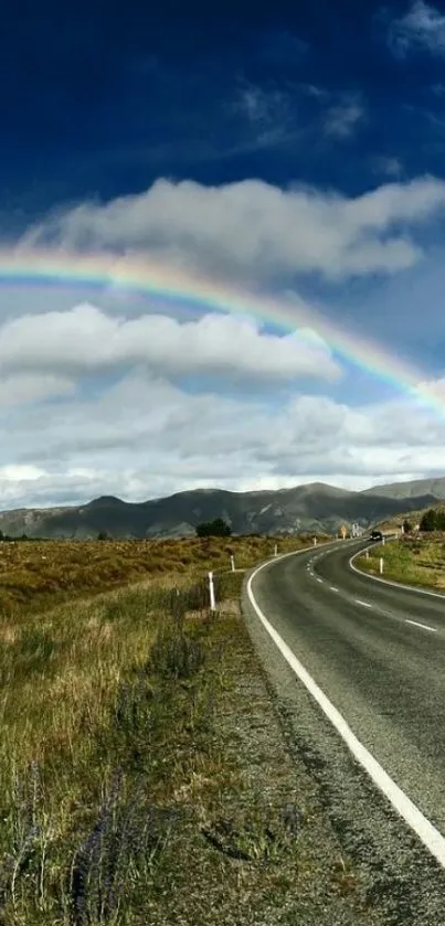 Road beneath a vivid rainbow under a lush blue sky.