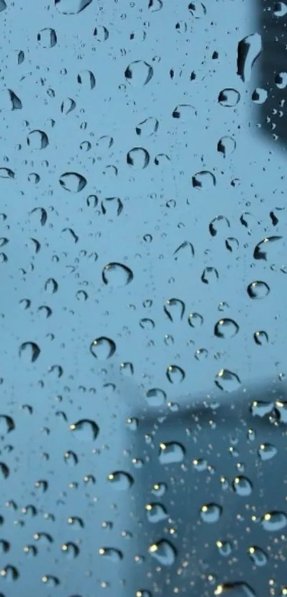 Raindrops on a window with a cityscape view in the background.