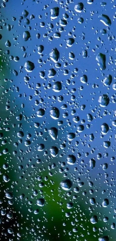 Raindrops on a clear glass with blurred blue and green background.