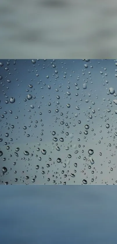 Raindrops on windowpane with blue gradient background.