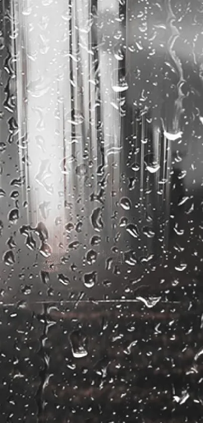 Close-up of raindrops on a glass surface reflecting a city skyline in grayscale.