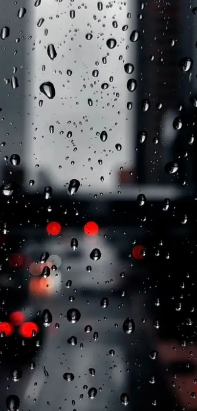 Raindrops on a window with a blurred cityscape background at night.