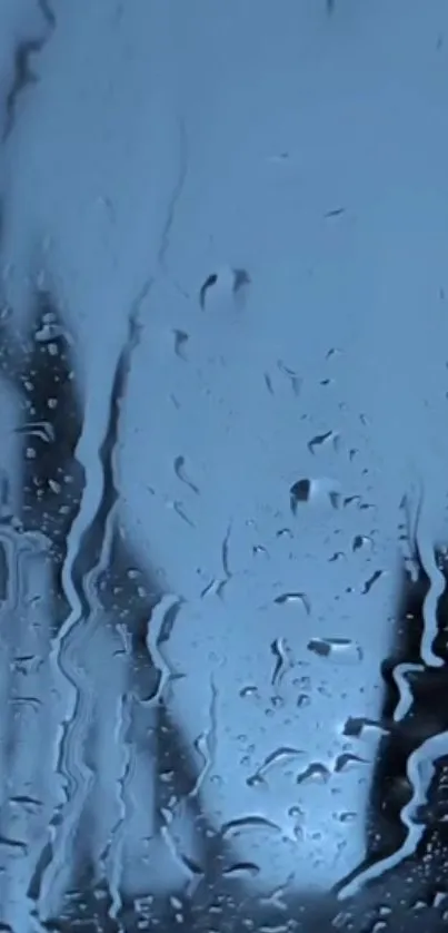 Blue rainy day wallpaper with raindrops on glass.