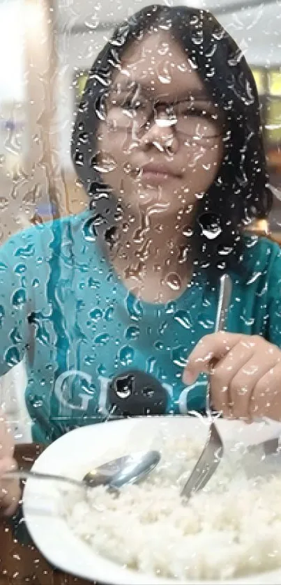 Person dining viewed through a rain-covered window.