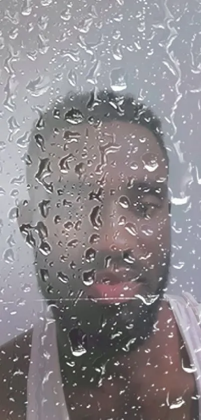 Man behind rain-covered glass, creating a serene wallpaper.