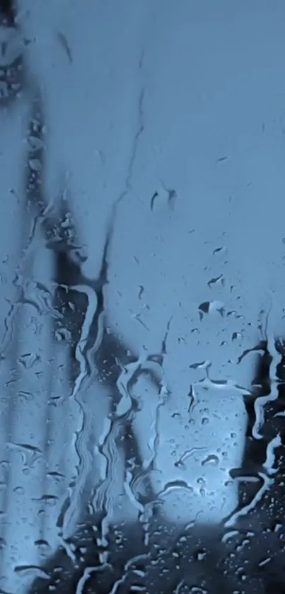 Close-up of raindrops on a glass surface, with a cool blue tone.