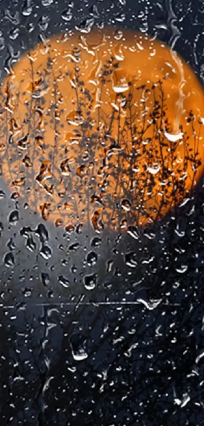 Orange moon behind raindrop-streaked glass on a nighttime background.