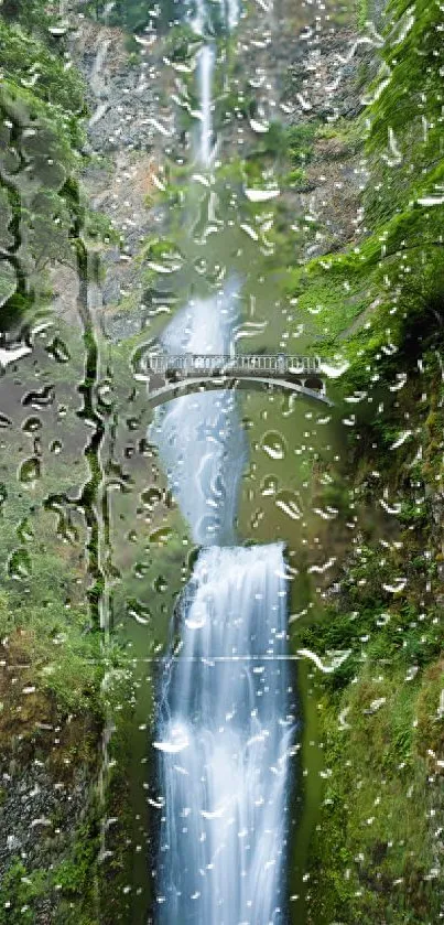 Waterfall with raindrops on glass and lush greenery.