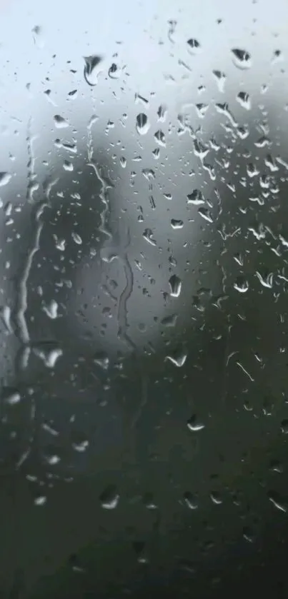 Mobile wallpaper with raindrops on a gray window.