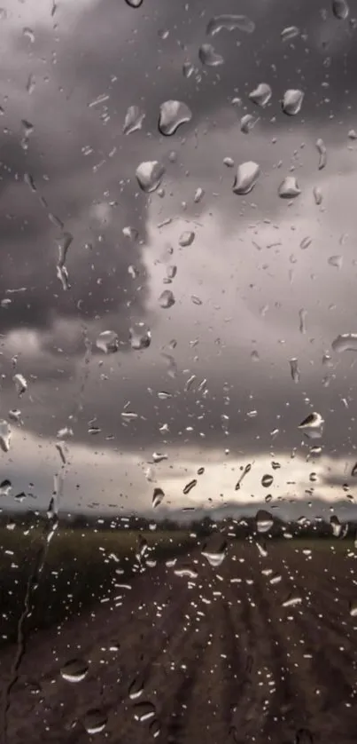 Raindrops on a window with dark, moody clouds in the background.