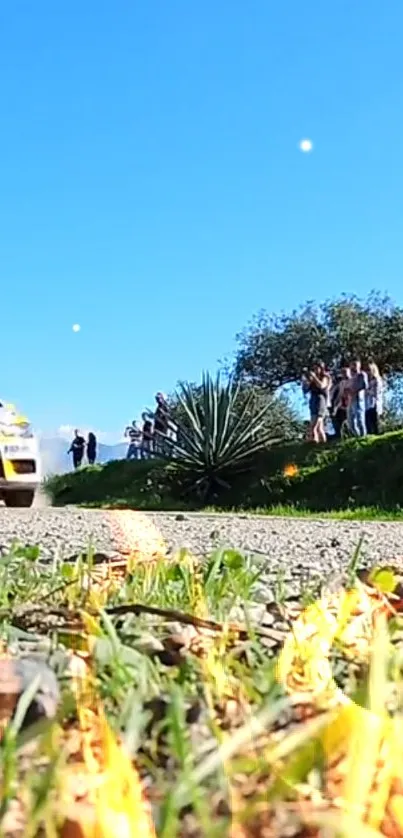 Rally car race in a scenic landscape with blue sky and nature.