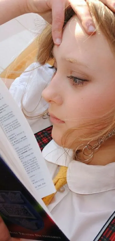 Girl in plaid dress attentively reading a book.