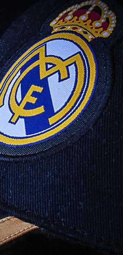 Real Madrid logo on dark blue background with golden details.