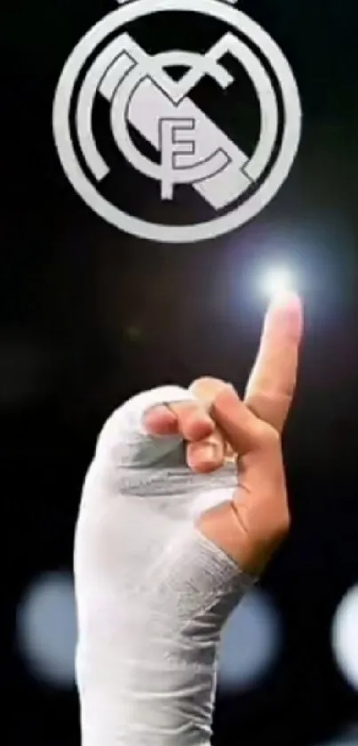 Real Madrid logo with wrapped hand pointing on black background.