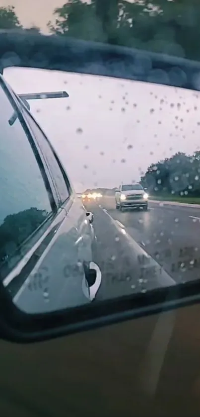 Rainy road seen through a car's rearview mirror, reflecting vehicles in motion.