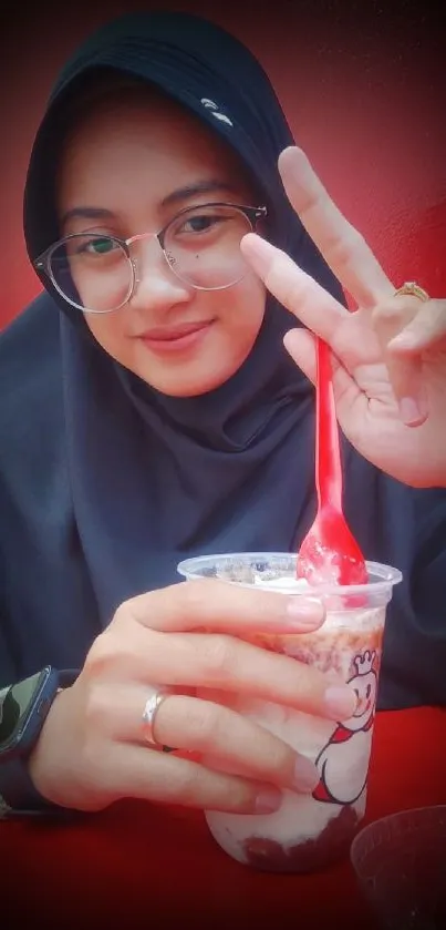 Smiling person enjoying ice cream with a red background.