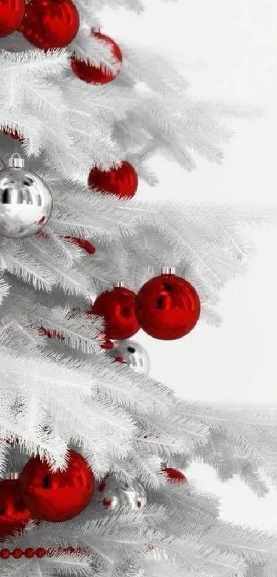 White Christmas tree with red ornaments decorating its branches.