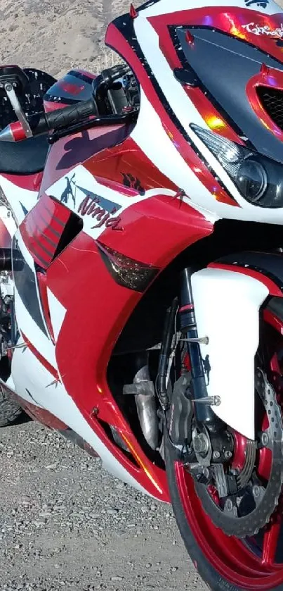 Red and white sport motorcycle on mountain road.