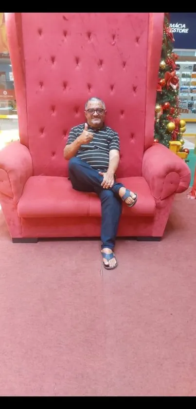 Man sitting on large red armchair, modern design wallpaper.