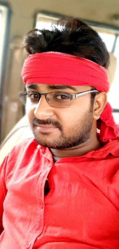 Man in a red shirt and headband portrait.