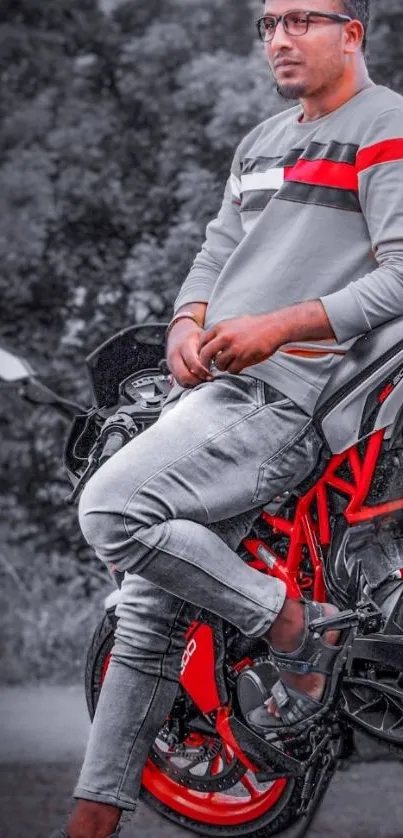 Young man on red motorcycle with grayscale backdrop.