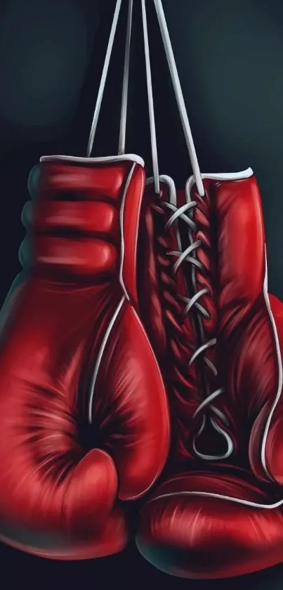 Hanging red boxing gloves against dark background.