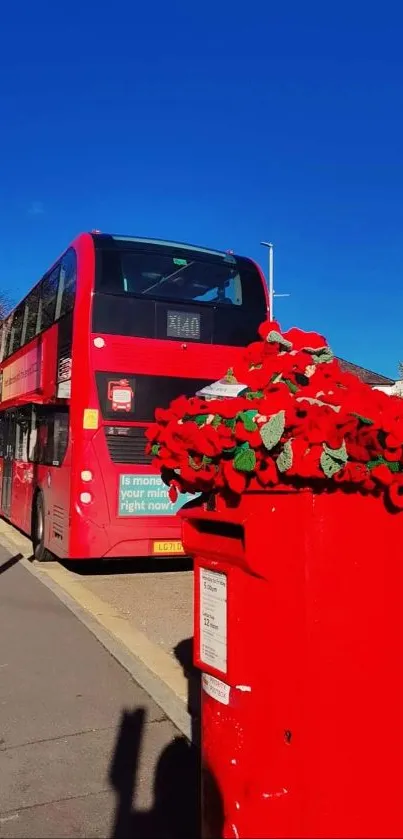 Red bus and floral display under blue sky