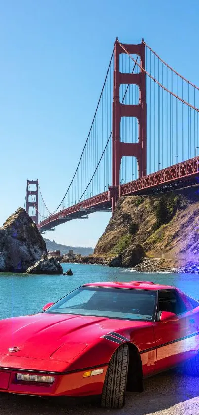 Red classic car parked by Golden Gate Bridge under clear blue sky.