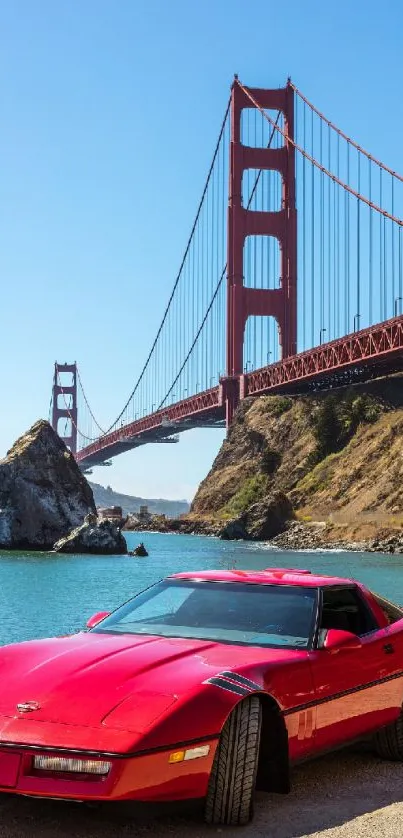 Red sports car parked by the Golden Gate Bridge under a clear blue sky.