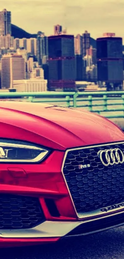 Red Audi car against city skyline wallpaper.