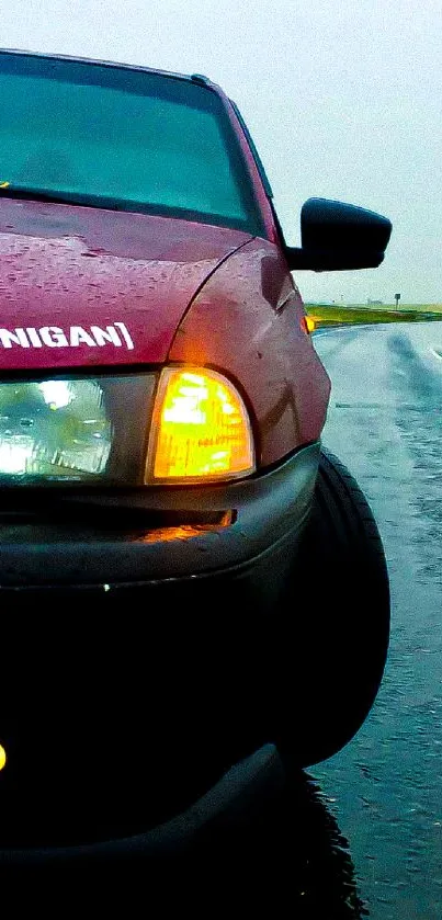 Red car driving on a wet and rainy road in dramatic fashion.