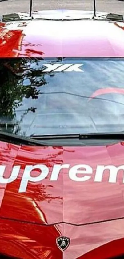 Red sports car with Supreme logo, glossy finish.