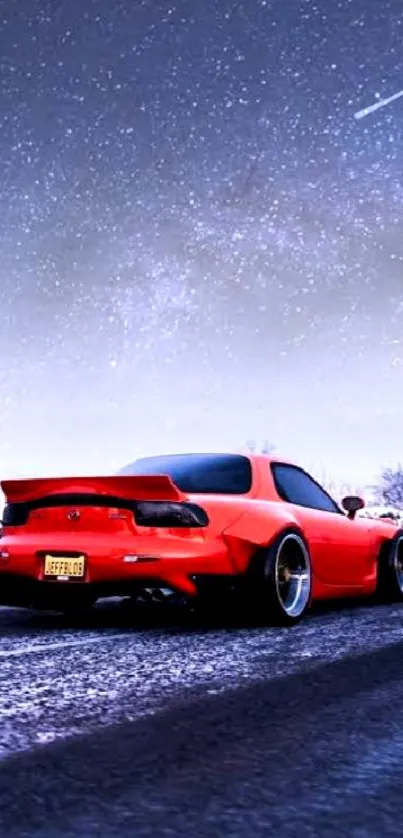 Red sports car on snowy road under a starry sky.